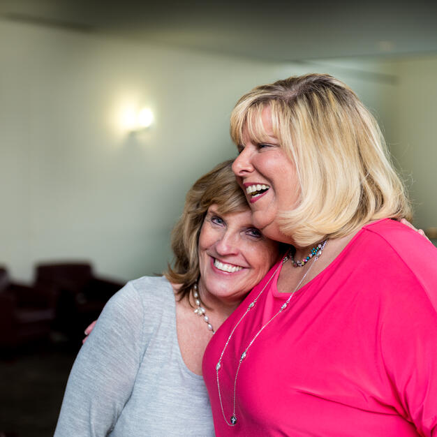 Two friends hugging happily