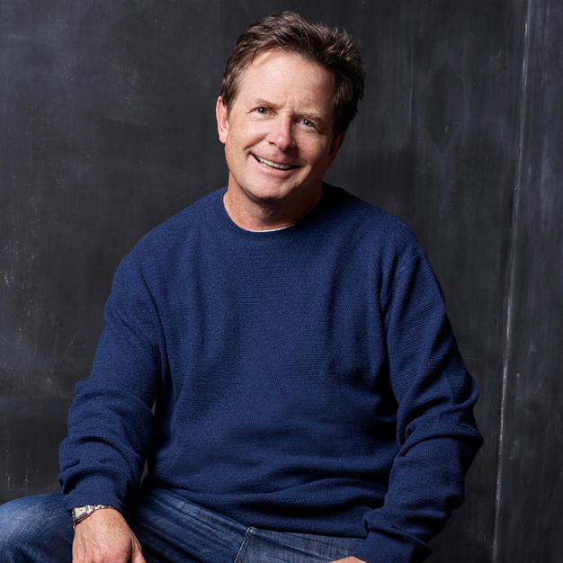 Michael J. Fox in blue sweater posing for the camera.