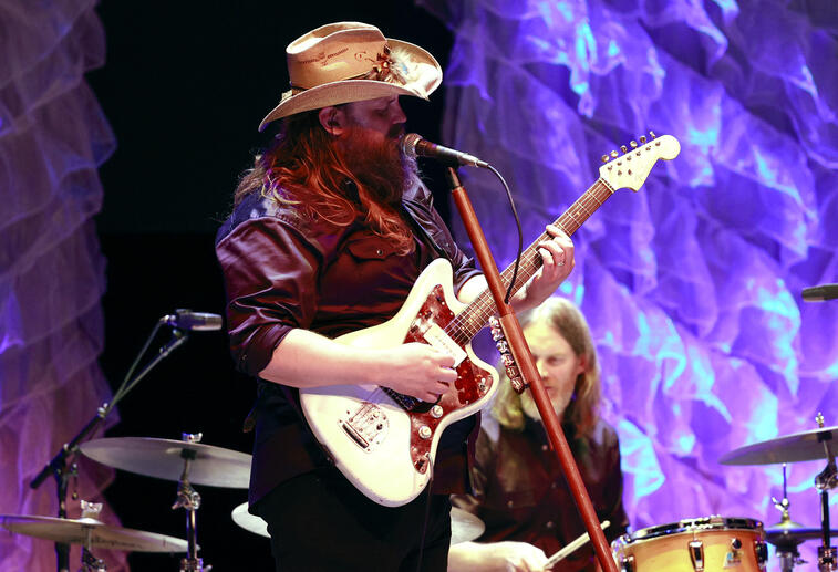 Chris Stapleton on the stage playing guitar and singing.