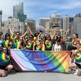 MJFF Staff posting with a rainbow banner with the MJFF logo on it