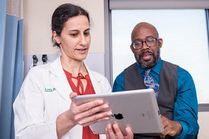 Doctor looking at iPad with patient