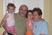 Two young children and older adults smiling at the camera.