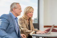 Man and woman sitting at a table with a laptop