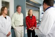 Researchers talking with couple in lab.