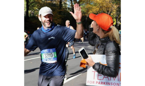 Gary gets a high five from Susie as he passes the Team Fox cheer zone at the 2018 New York City Marathon.