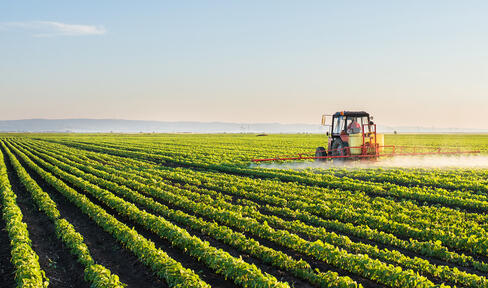 tractor sprays paraquat on crops