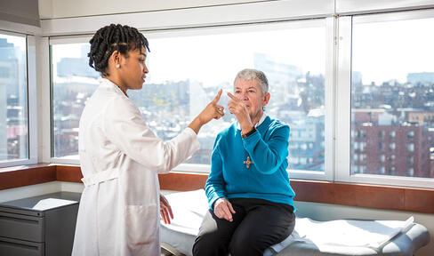 A doctor checks a patient in an office overlooking a city.