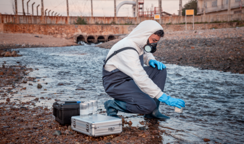 Person tests water for chemical contamination.