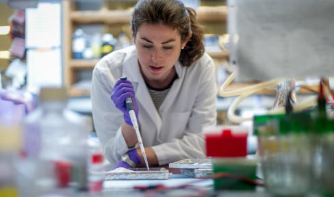 Female researcher in lab with pipette.