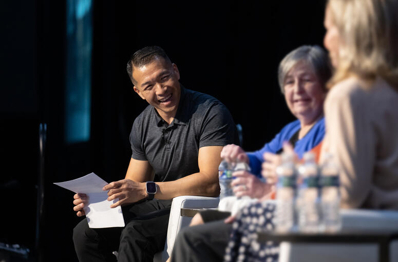 Jimmy Choi speaks with guests on stage at a panel event