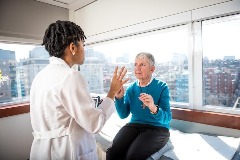 A doctor working with a patient in an examination room.