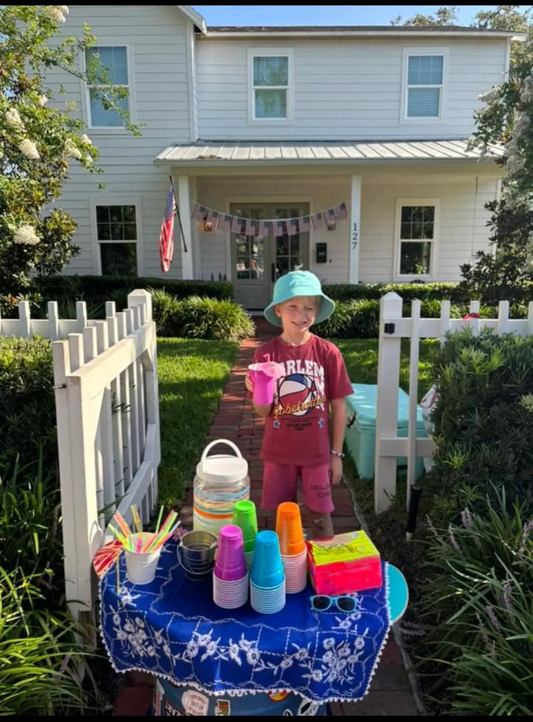 Teddy sets-up a lemonade stand outside the front of his family home. 