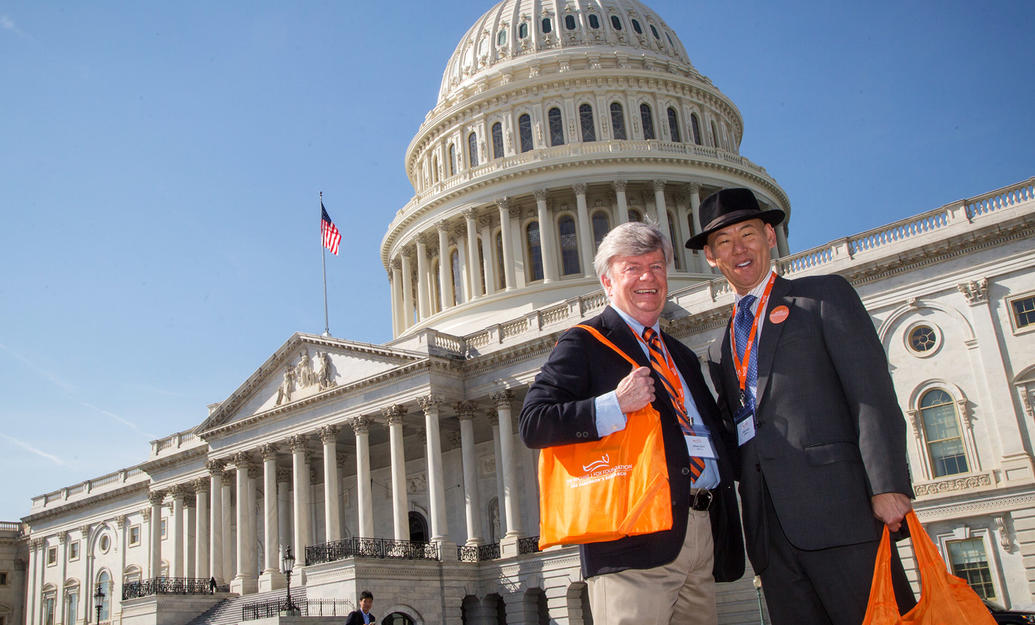 Two male advocates in front of the United States Capitol building at the Parkinson's Policy Forum.