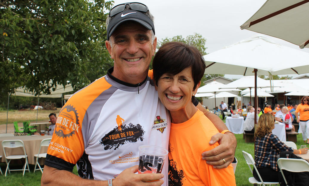 Male and female couple smiling for the camera at a Tour de Fox cycling event.