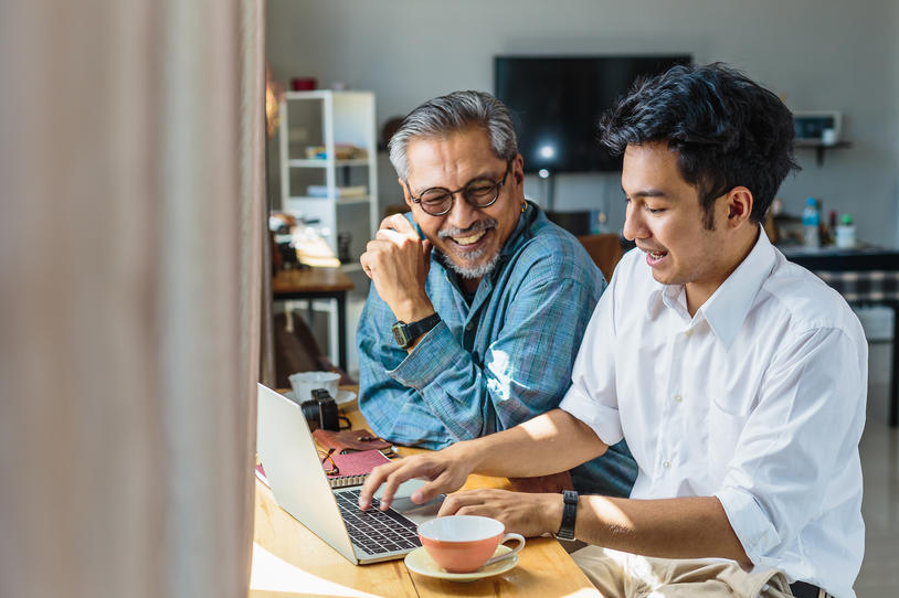 Two people smiling looking at laptop