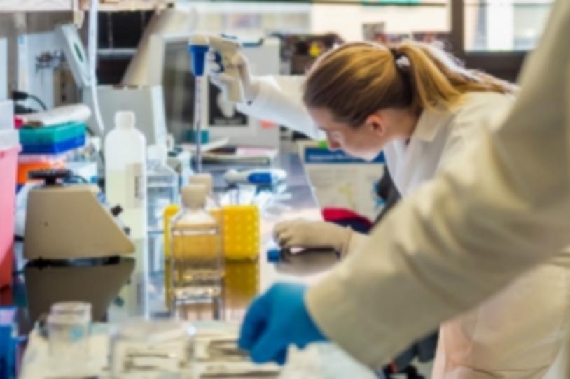 Female researcher in lab with tool.