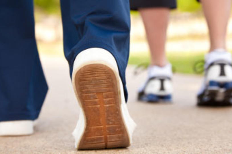 Two people wearing sneakers walking.