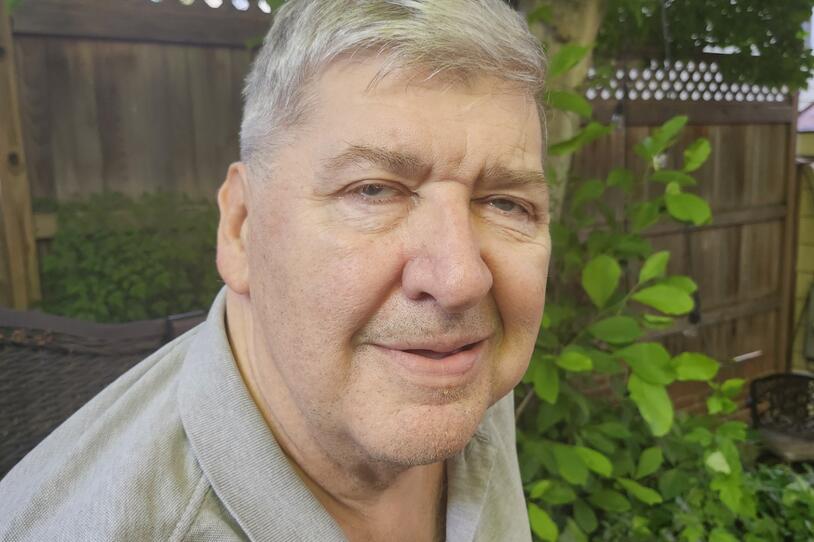 A photograph of Jim O'Connell smiling in a backyard.