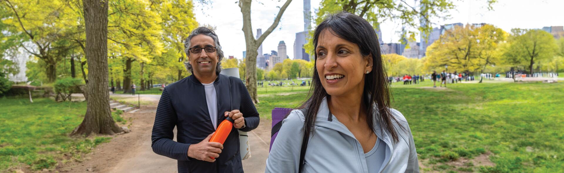 A smiling couple walking through the park