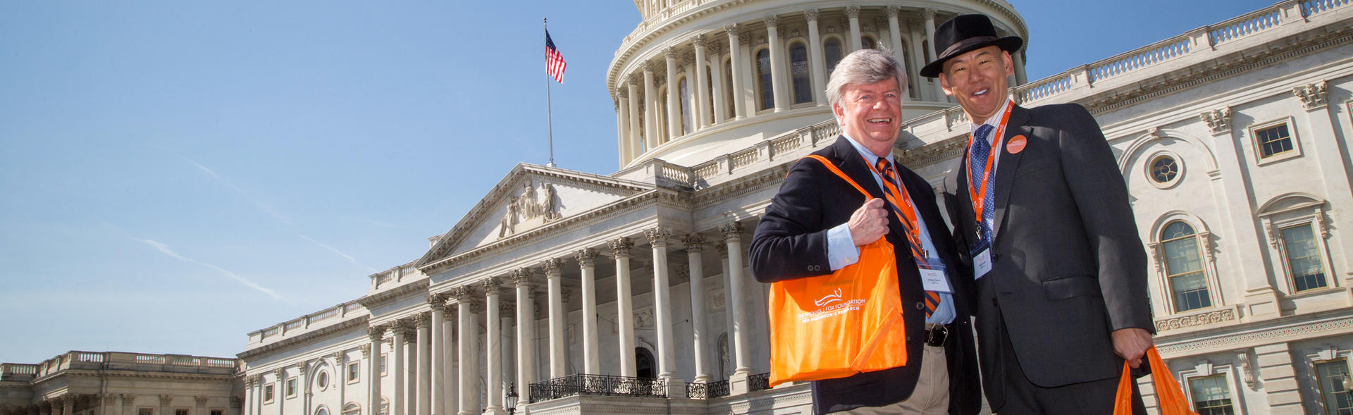 Two male advocates in front of the United States Capitol building at the Parkinson's Policy Forum.