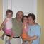 Two young children and older adults smiling at the camera.
