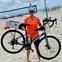 Bethany Richards holding bike on the beach.