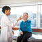 A doctor checks a patient in an office overlooking a city.