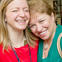 Two females smiling and embracing in the doctor's office.